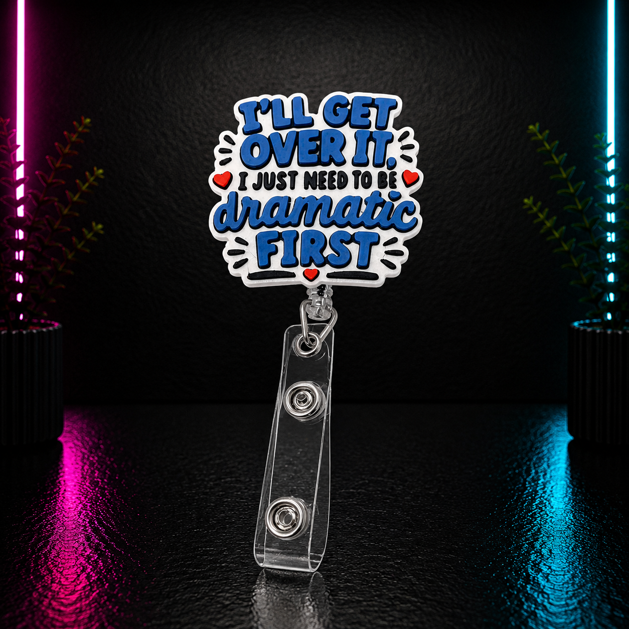 Funny retractable badge reel featuring the quote "I'll Get Over It, I Just Need to Be Dramatic First" in layered blue, white, black, and red lettering for nurses, teachers, and office professionals.